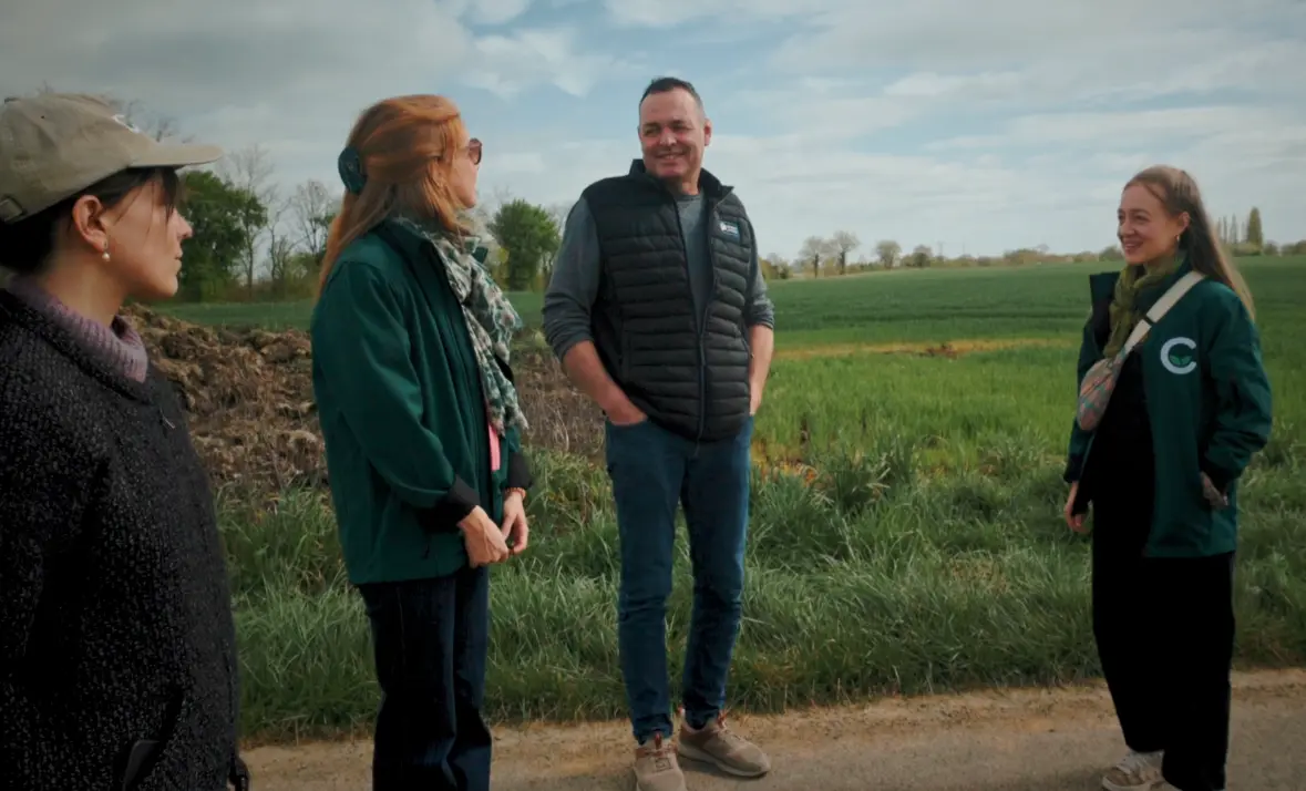 un éleveur et 3 membres de carbone farmers devant un champ